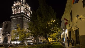 Un bâtiment historique doté d’une tour imposante, d’une allée pavée et d’un drapeau.