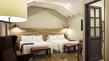 Habitación de hotel con dos camas, cabecero de madera, escritorio y una silla.