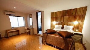 Une chambre à coucher comprenant un lit, une table de chevet, une chaise et un bureau.