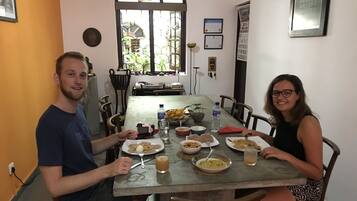 Una mesa con platos de comida, una botella de agua y un tazón.