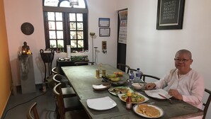 A dining area with a long table, chairs, and various dishes. - Breeze of Paradise (Nugegoda)