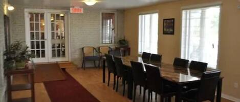 A dining area with a long table and chairs, a red carpet, and a sign that reads "SMILE".