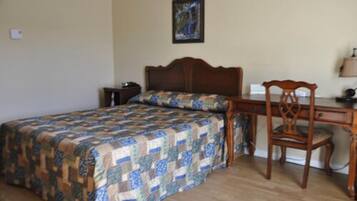 A bedroom with a wooden bed, a desk, and a chair.