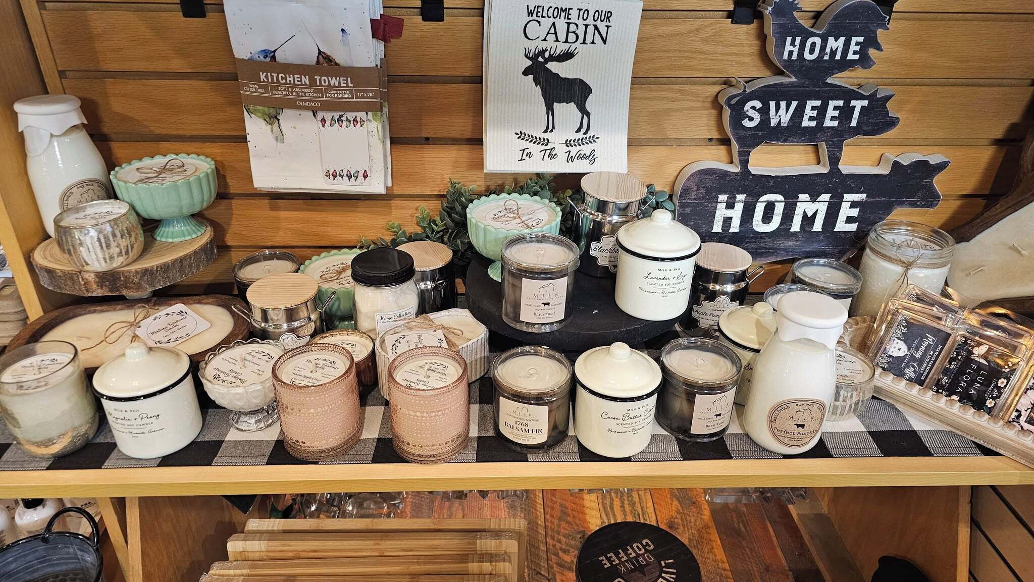 Una exhibición de velas y toallas de cocina en un ambiente rústico tipo cabaña.