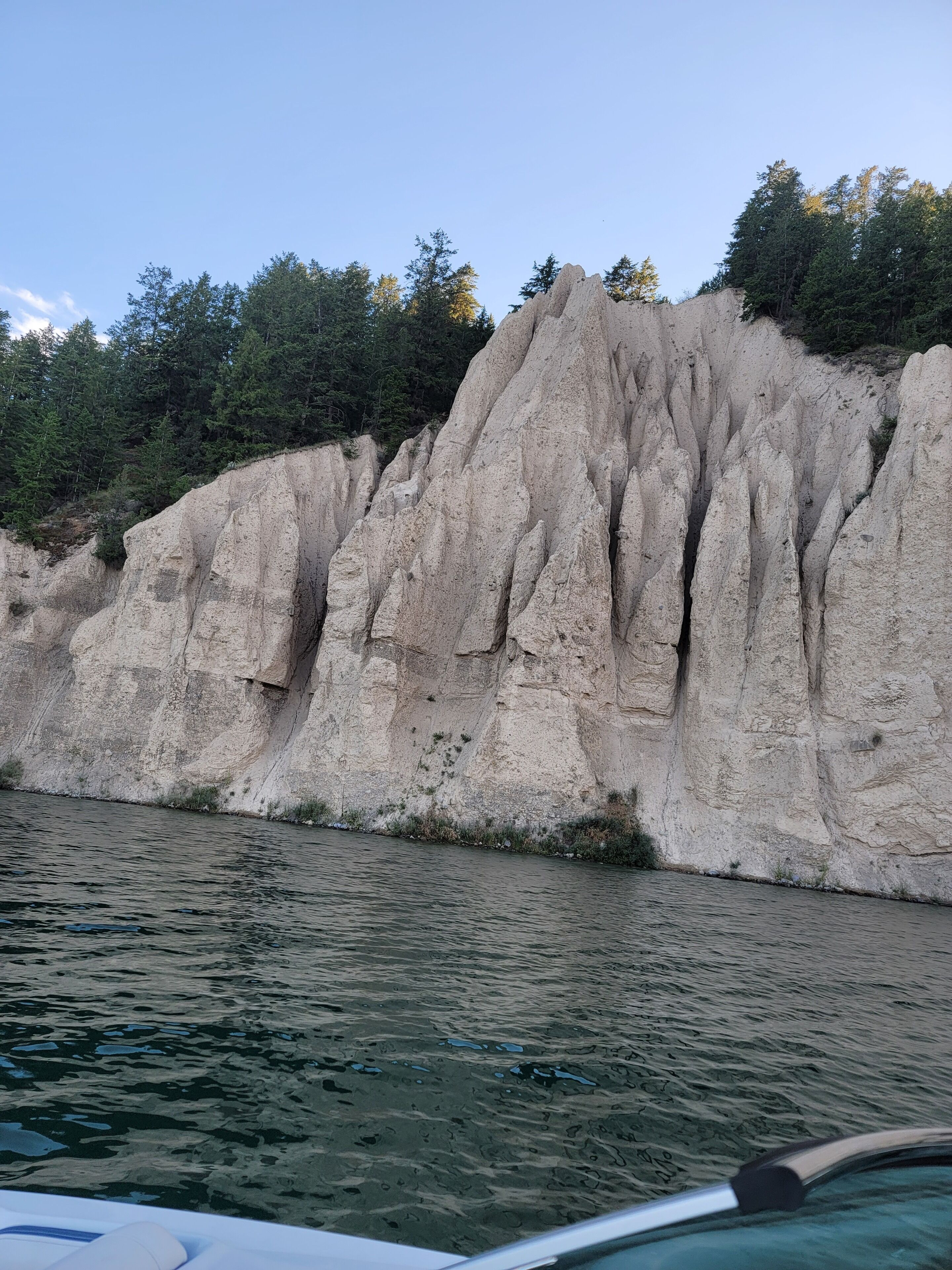 A rocky cliff by a body of water.