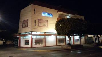 A hotel named "Australia Suites & Executive" with signage indicating "Suites Equipadas" and "1 Ano."