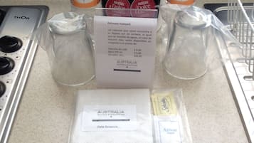 A kitchen counter with a coffee maker, two bottles of Bonafont water, a receipt, and some packaged items.