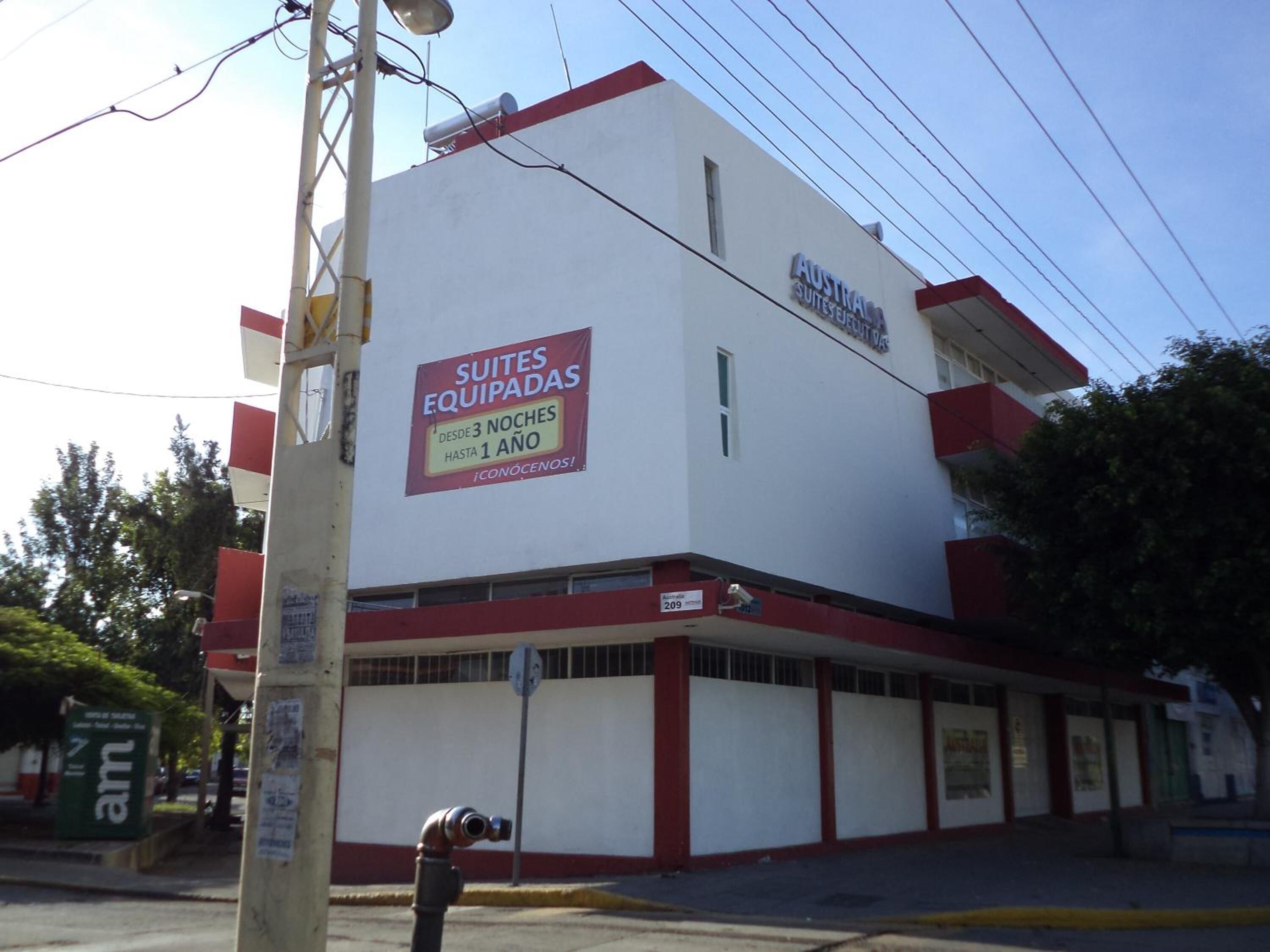 A building with a sign advertising 'Suites Equipadas' available from 3 nights until 1 year.