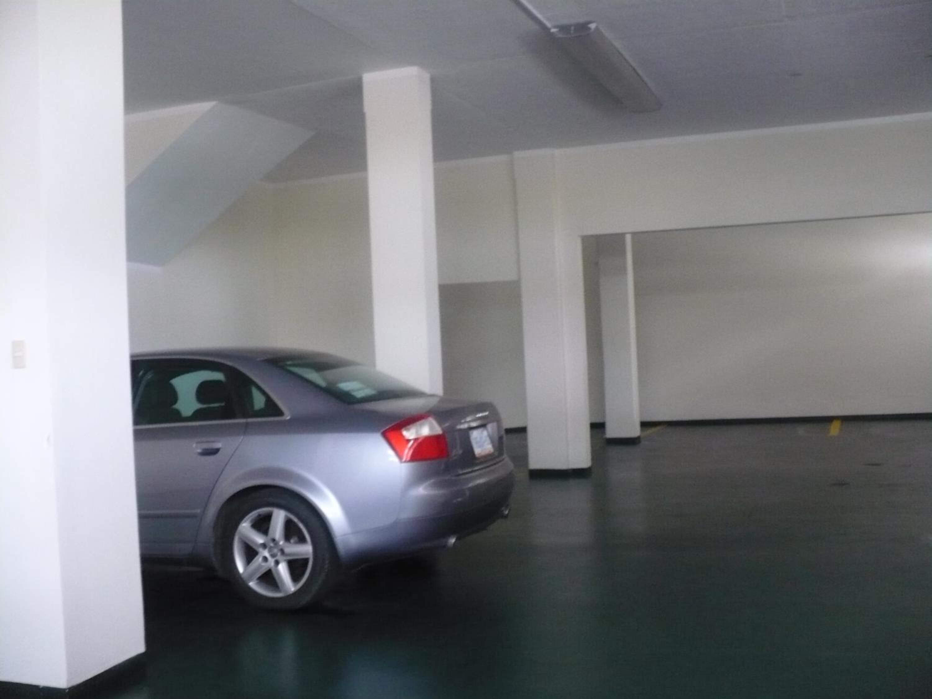 Un aparcamiento con un coche estacionado.