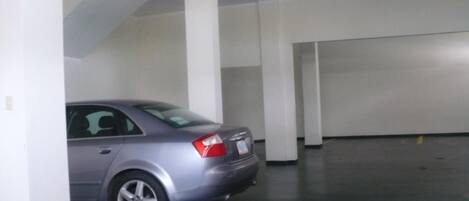 Un aparcamiento con un coche estacionado.