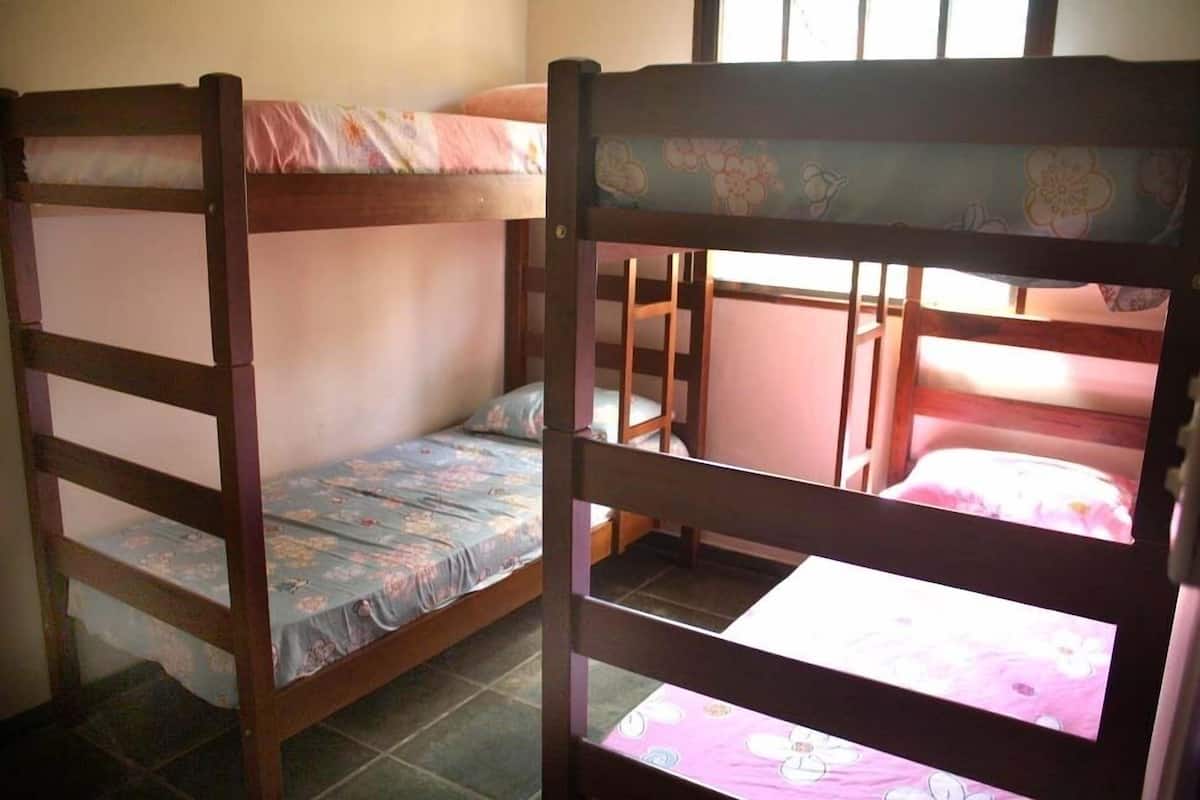 A room with two bunk beds, each with a floral-patterned bedspread.