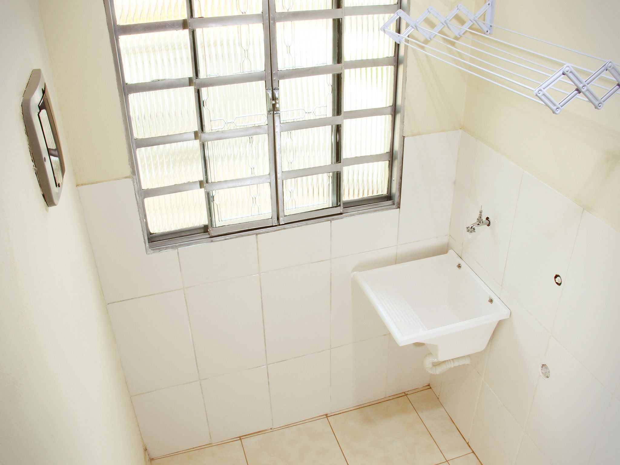 A small bathroom with a window, a sink, and a towel rack.