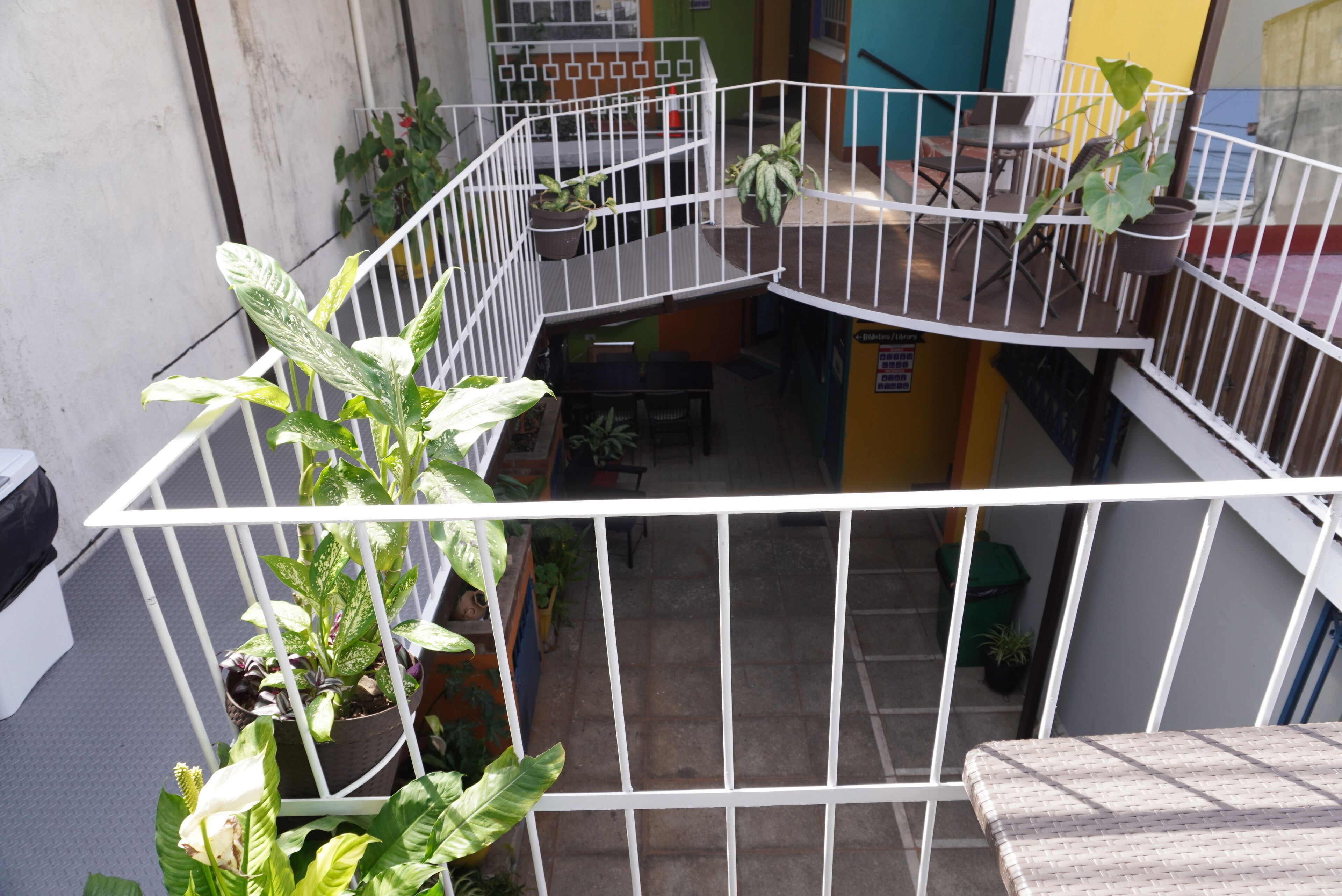 A multi-level outdoor balcony with potted plants and seating areas.