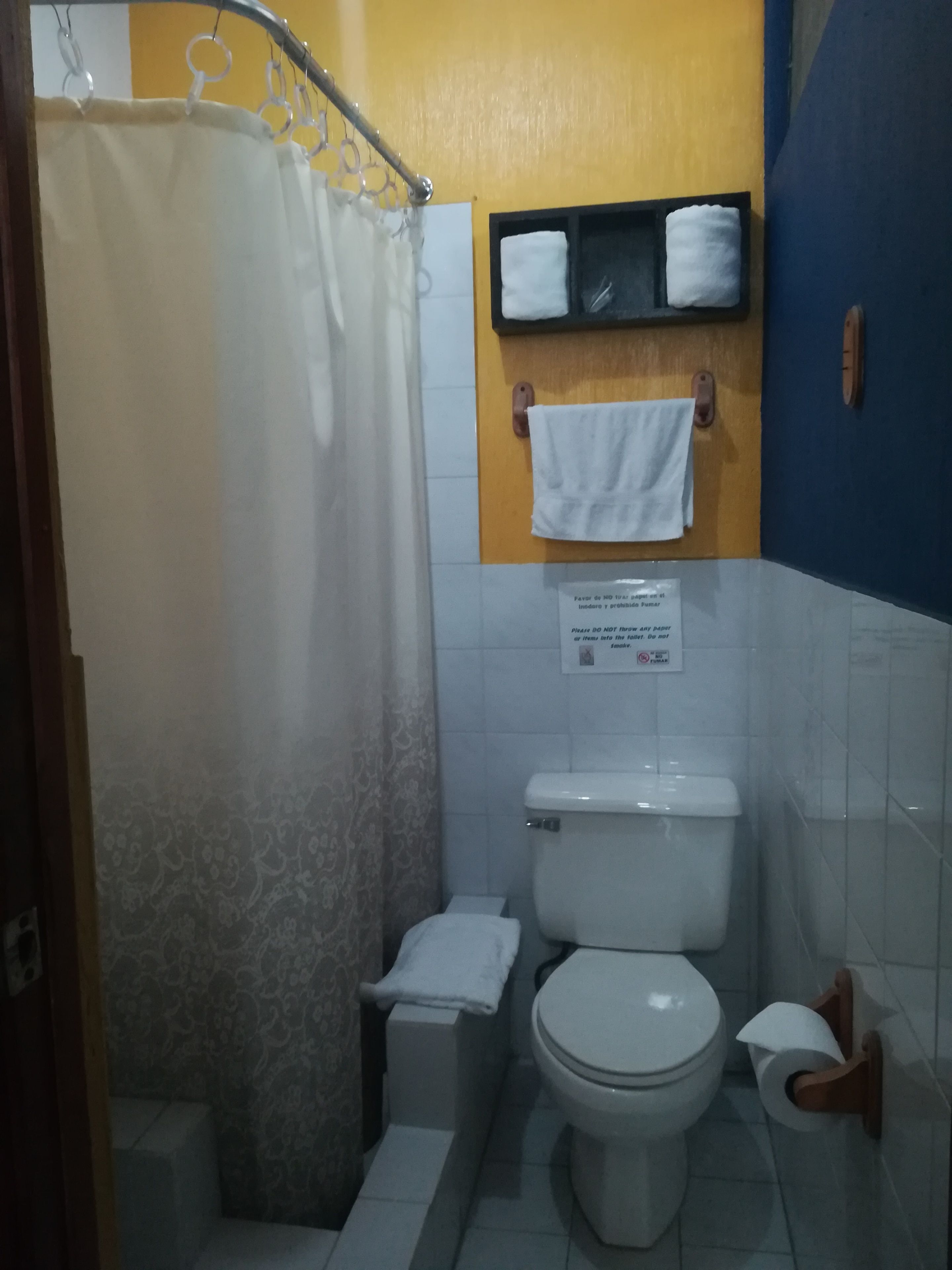 Un baño con ducha, inodoro y toallero con dos toallas.