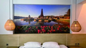 A bedroom with a large wall mural of a temple and lotus pond, two wicker lamps, and a neatly made bed with white pillows. - Fastrooms Bekasi Hotel (Bekasi)