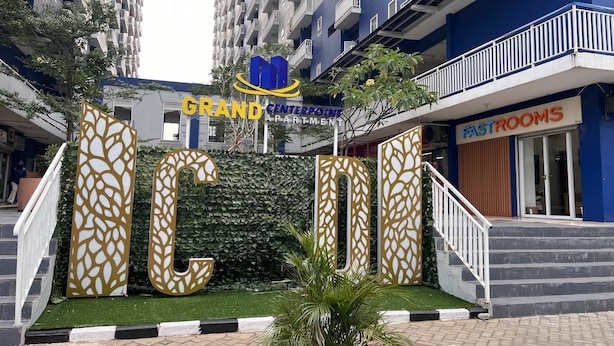 A hotel entrance with a large decorative sign, a staircase, and a sign for fast rooms. - Fastrooms Bekasi Hotel (Bekasi)