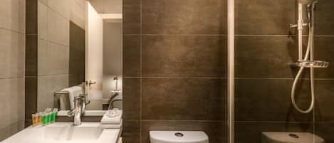 A modern bathroom with a shower, toilet, and sink.