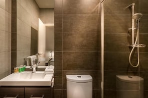 Un baño moderno con ducha, inodoro y lavamanos.