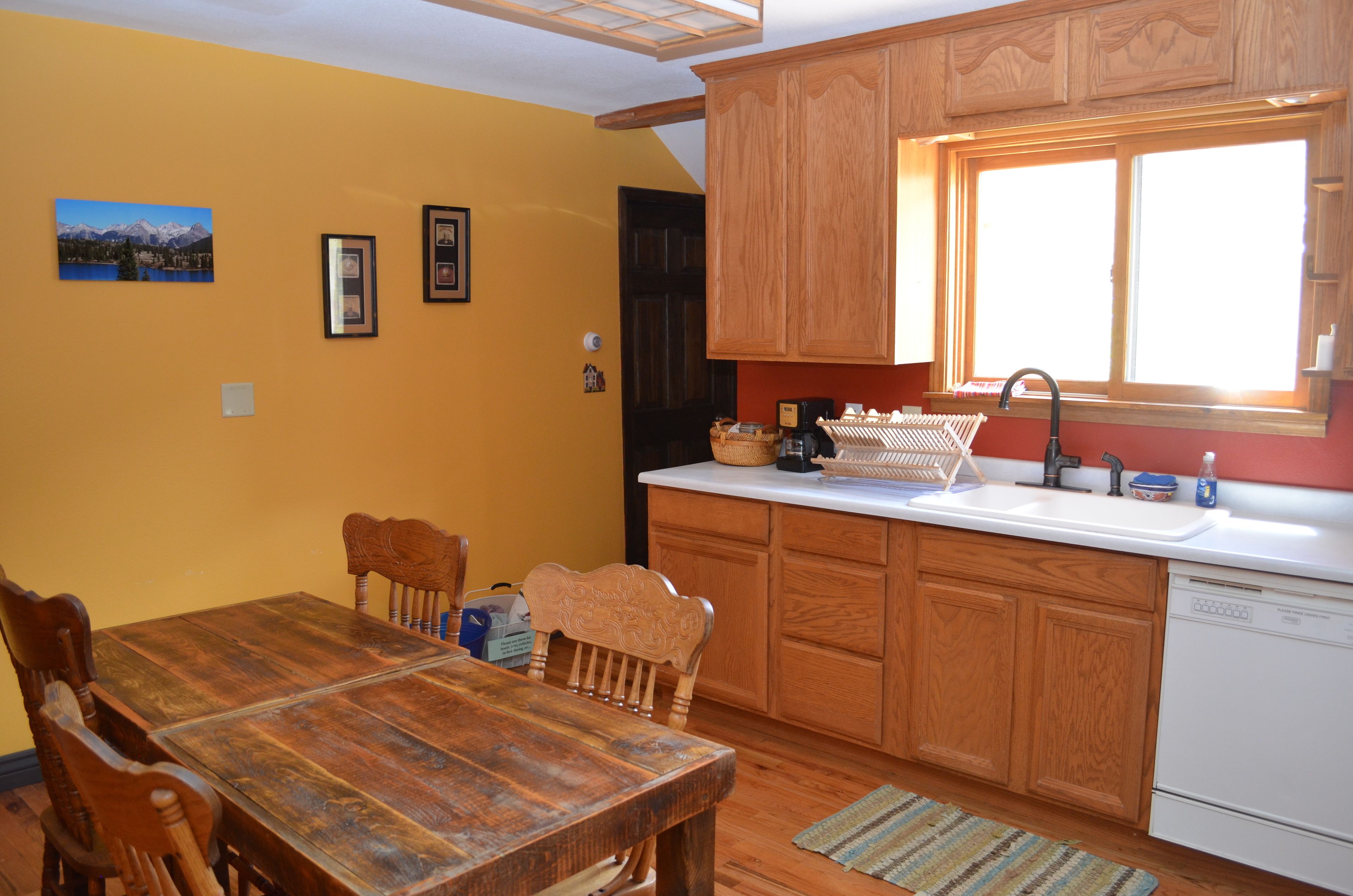 A kitchen with wooden cabinets, a white countertop, and a window.