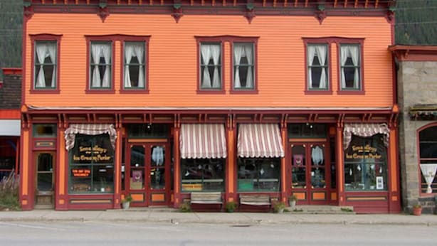 A two-story building with a red facade, multiple windows, and awnings. - Smedley's Suites (Silverton)