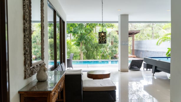 Un interior moderno con piscina, ventanas amplias y zona de estar.