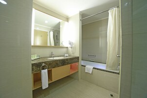A modern bathroom with a marble sink, a large mirror, a shower with a glass door, and a towel rack.