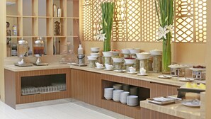 A buffet setup with various dishes, a decorative wall, and a wooden counter.