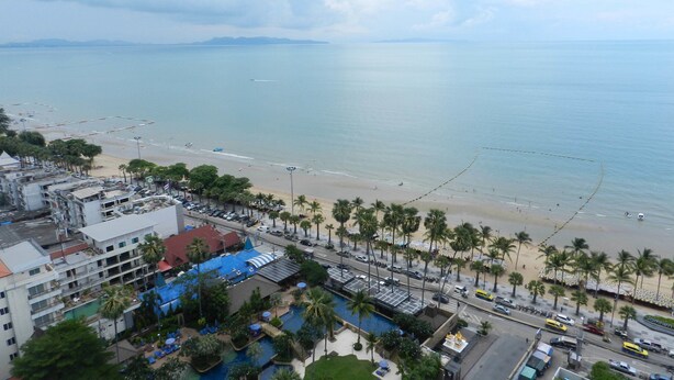 Un hotel junto a la costa con piscina, acceso a la playa y vistas al mar.