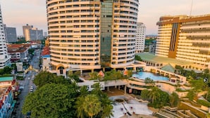 Un hotel moderno con un patio central, varios pisos y edificios urbanos circundantes.