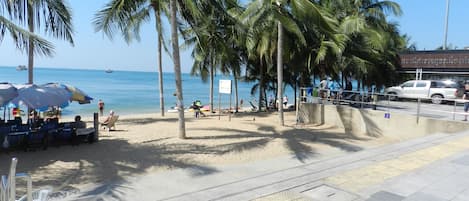 Rannalla, aurinkotuoleja, aurinkovarjoja, rantapyyhkeitä