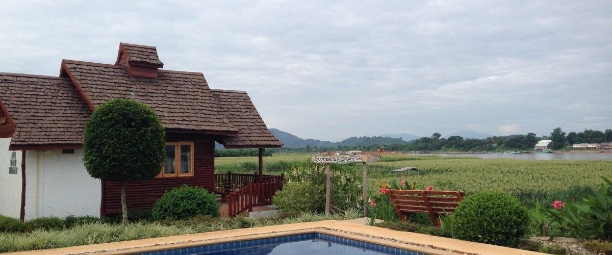 Una casa con piscina, rodeada de jardín y vista al río.