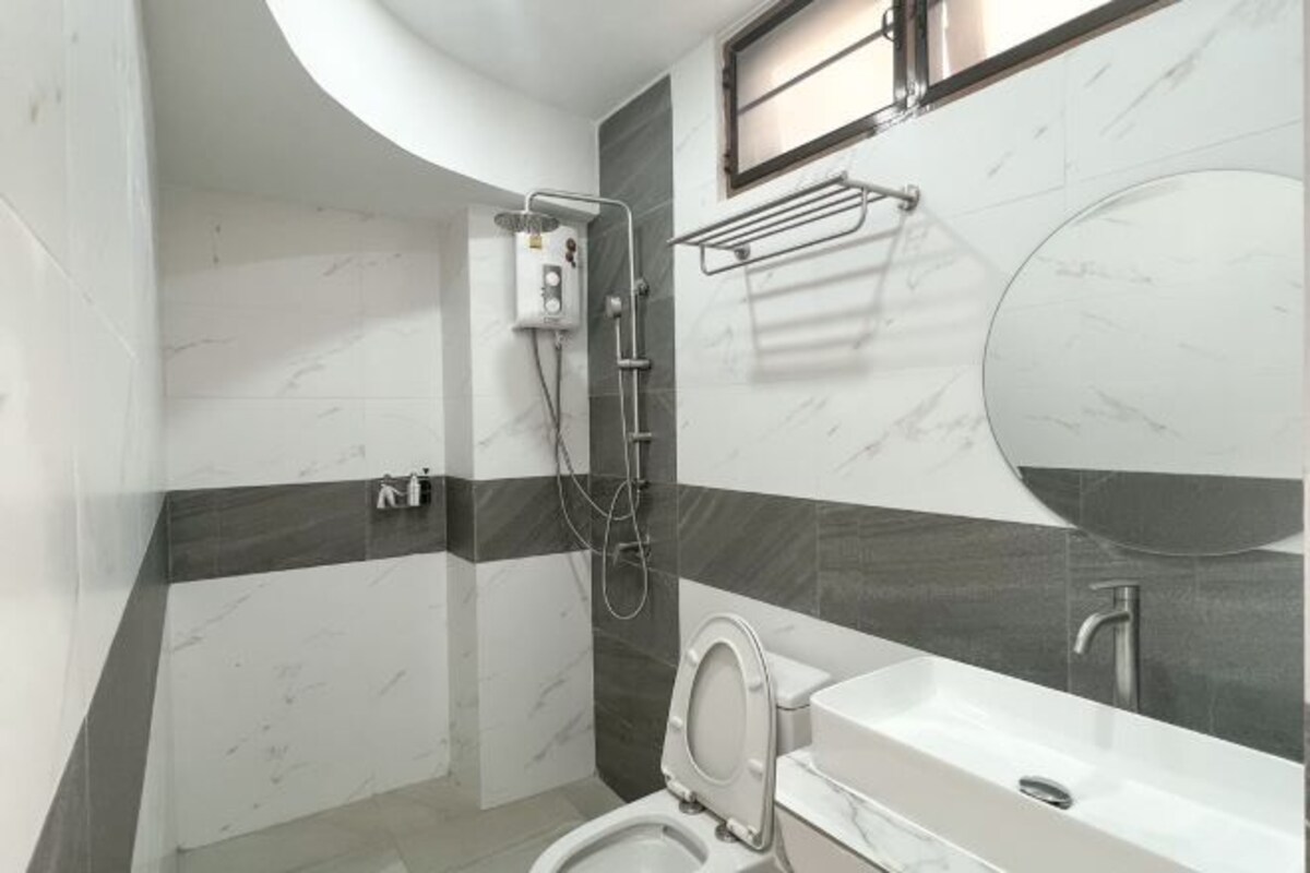 Een moderne badkamer met toilet, wastafel en douche.