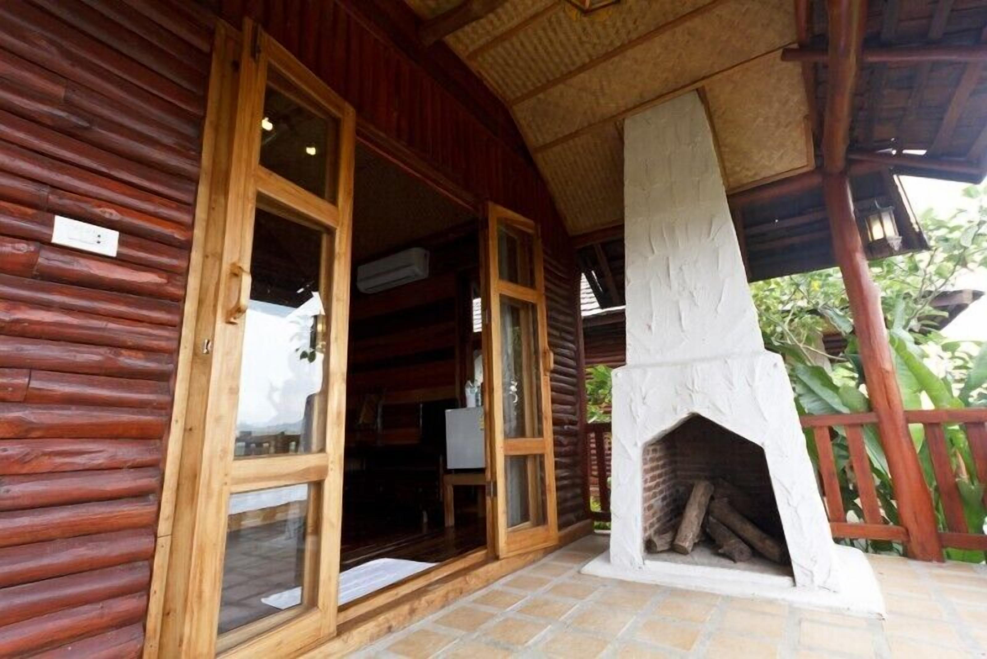 Eine Holzhütte mit Kamin, einer Holztür und einem gefliesten Boden.