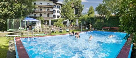 Una piscina al aire libre, tumbonas