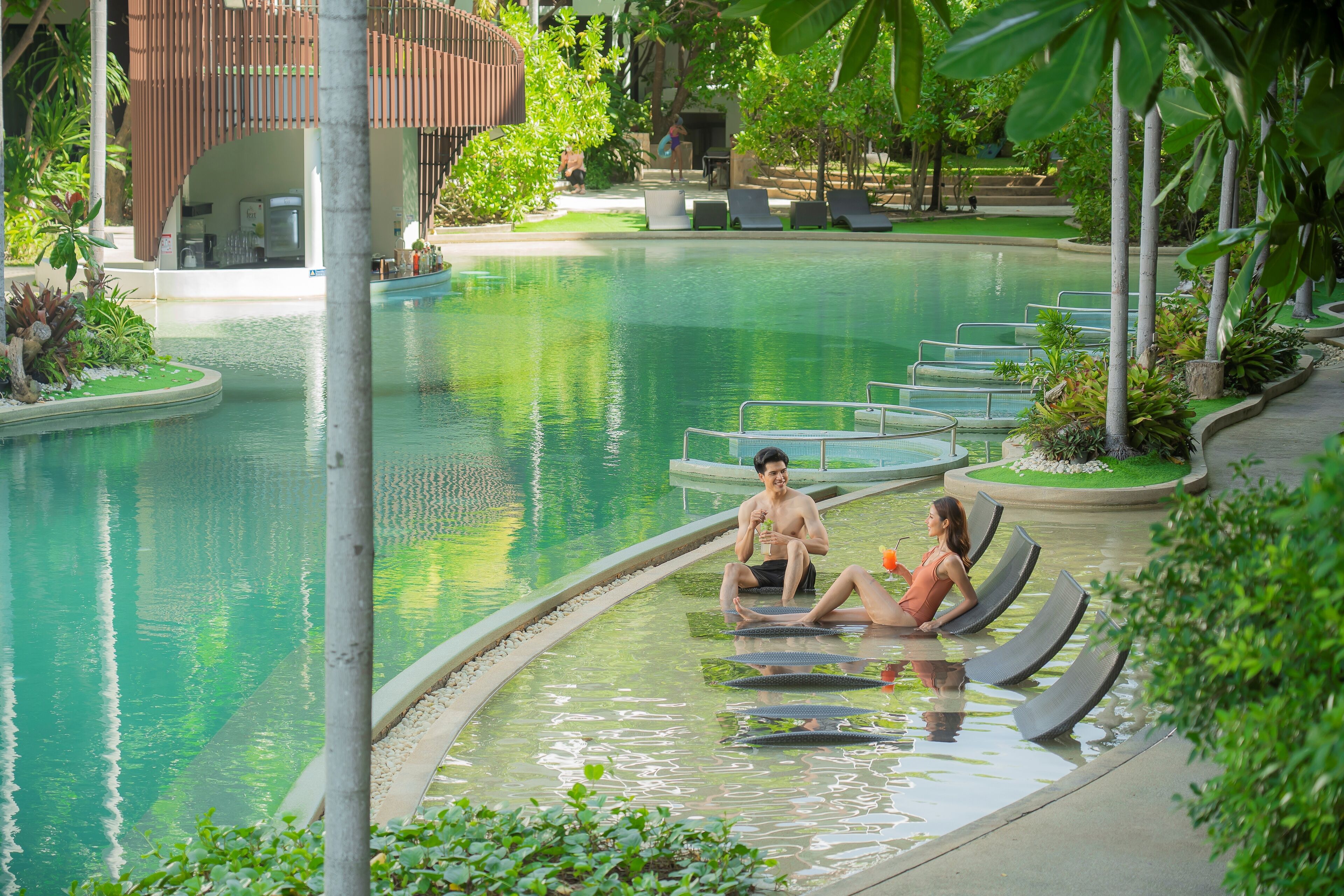 A swimming pool with lounge chairs and a building in the background.