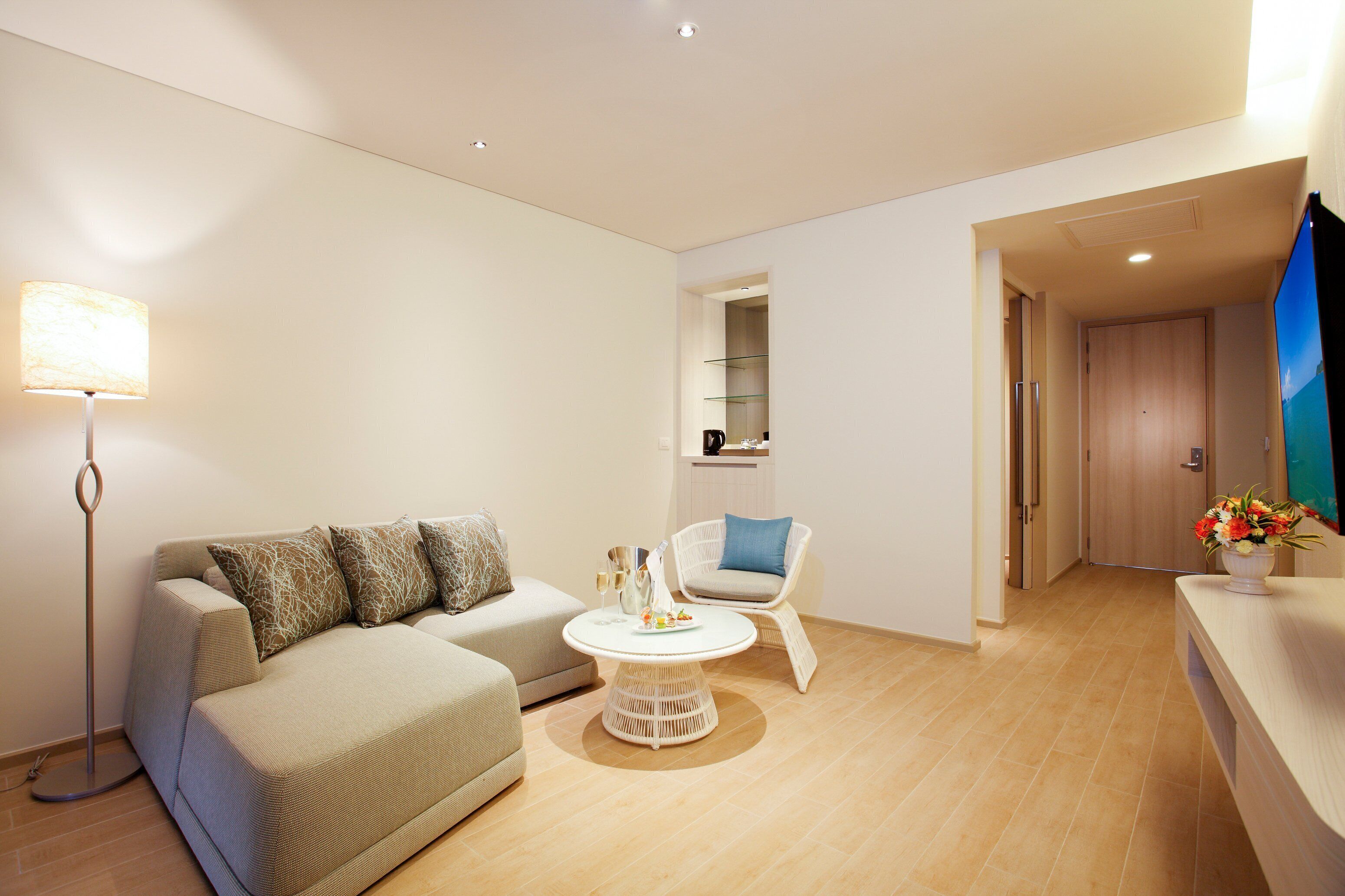 A modern living room with a sofa, a chair, a coffee table, and a flat-screen TV.