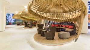 A lounge area with thatched-roof seating and modern furniture.