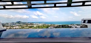 A view from a balcony overlooking a coastal town with a clear sky and calm sea. - Aqua Samui Villas (Koh Samui)