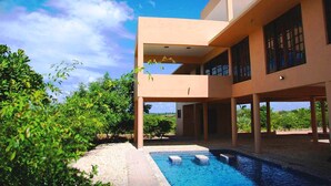 A modern two-story building with a swimming pool and outdoor seating area. - Deacra Villas By Sol Resorts (Vilanculos)