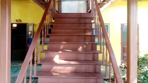 Un escalier en bois, doté d’une rampe, mène à un palier.