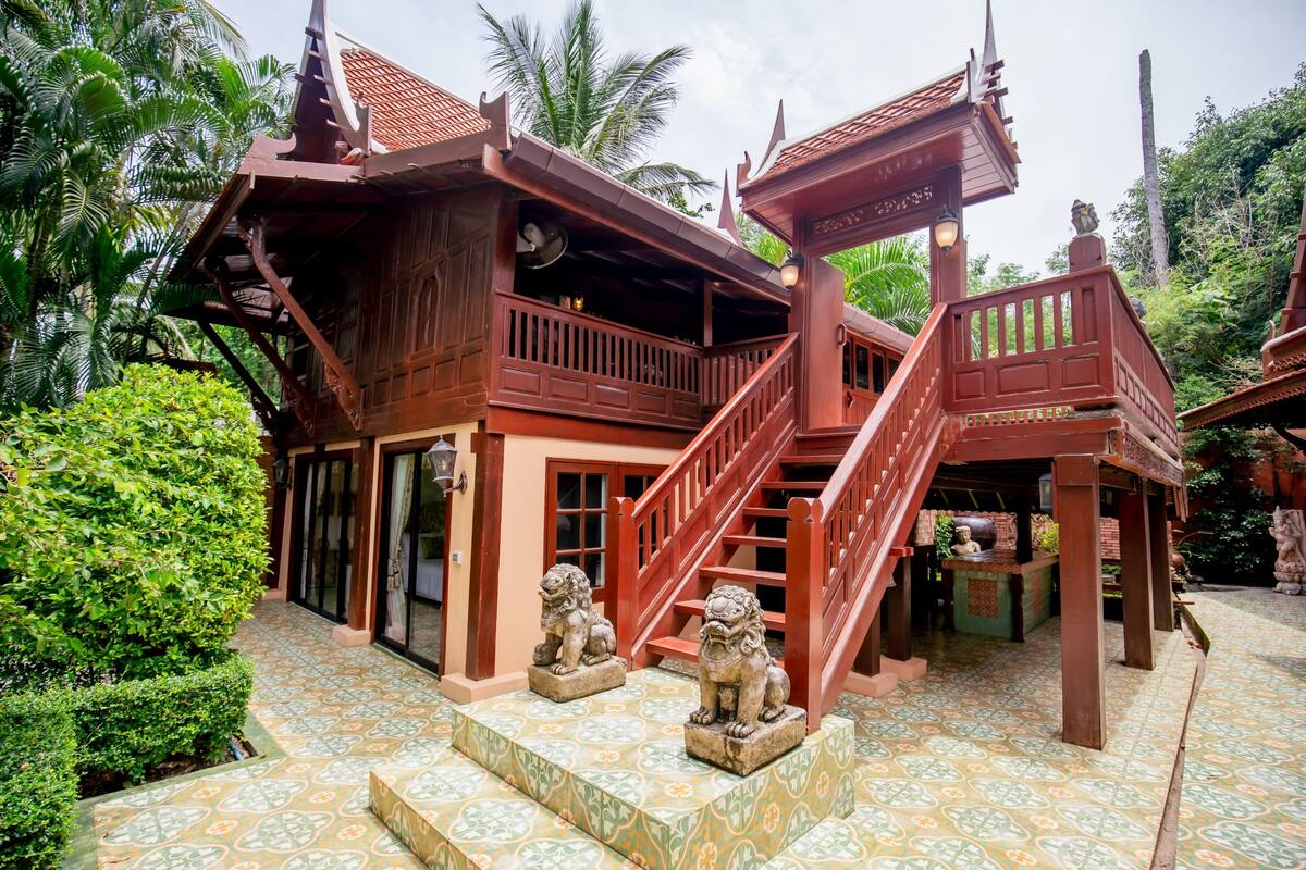 Un bâtiment traditionnel en bois, doté d’un escalier et de statues de lions.