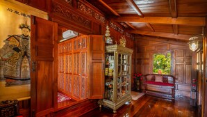 Ein traditionell eingerichteter Holzraum mit einem großen, verzierten Schrank, einer Glasschiebevitrine und einer Sitzbank.