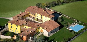 A large yellow building with multiple sections and a swimming pool. - Agriturismo Macesina (Bedizzole)