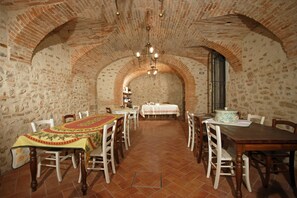 A dining area with brick walls, arched ceilings, and a chandelier. Tables are set with white tablecloths and chairs. - Agriturismo Macesina (Bedizzole)