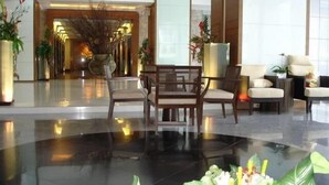 A modern lobby with a polished floor, a reception desk, and seating areas. - Baan Sathorn Riverfront (Bangkok)