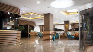 A modern hotel lobby with a reception desk, seating areas, and a glass partition. - The Rise Aron Business Hotel Merter (Istanbul)