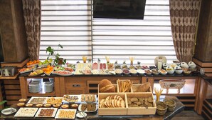 A buffet table with various food items and a potted plant. - The Rise Aron Business Hotel Merter (Istanbul)