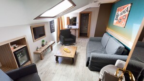 A compact living space with a sofa, a coffee table, a TV, a small table with a plant, and a bench. - The Rise Aron Business Hotel Merter (Istanbul)