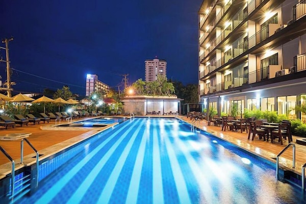 Una piscina al aire libre, sillones reclinables de piscina