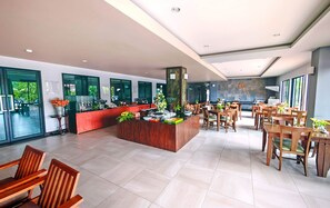 A spacious hotel lobby with a reception desk, multiple seating areas, and large windows offering views of the outdoors. - Savotel (Sattahip)